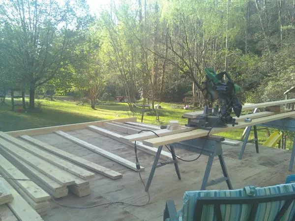 Miter saw and framing lumber on a deck under construction in Lansing
